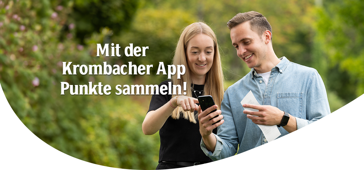 zwei Personen mit einem Handy in der Hand, die auf das Smartphone zeigen