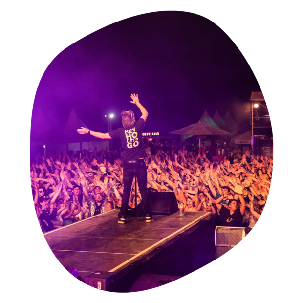 Große Menschenmenge bei Krombacher Festivalsommer am Elbstrand Festival mit Bühne und Beleuchtung