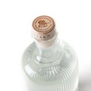 Flasche mit geriffeltem Glas und Holzverschluss, auf dem 'PRÄMIERTE QUALITÄT' eingraviert ist.