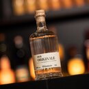 Flasche Krombacher Bierbrand 'Der Originale' mit 0,5 l Inhalt und 38 % Volumen, gerilltes Glas, auf dunklem Untergrund vor unscharfem Hintergrund.