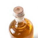 Flasche mit goldenem Bierbrand, Holzverschluss mit Prägung und Text 'PREMIERTE QUALITÄT' und Blätter-Motiv.