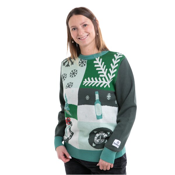Person trägt einen grünen Pullover mit weißen Schneeflocken, Flaschenmotiv und Krombacher-Logo am Ärmel.